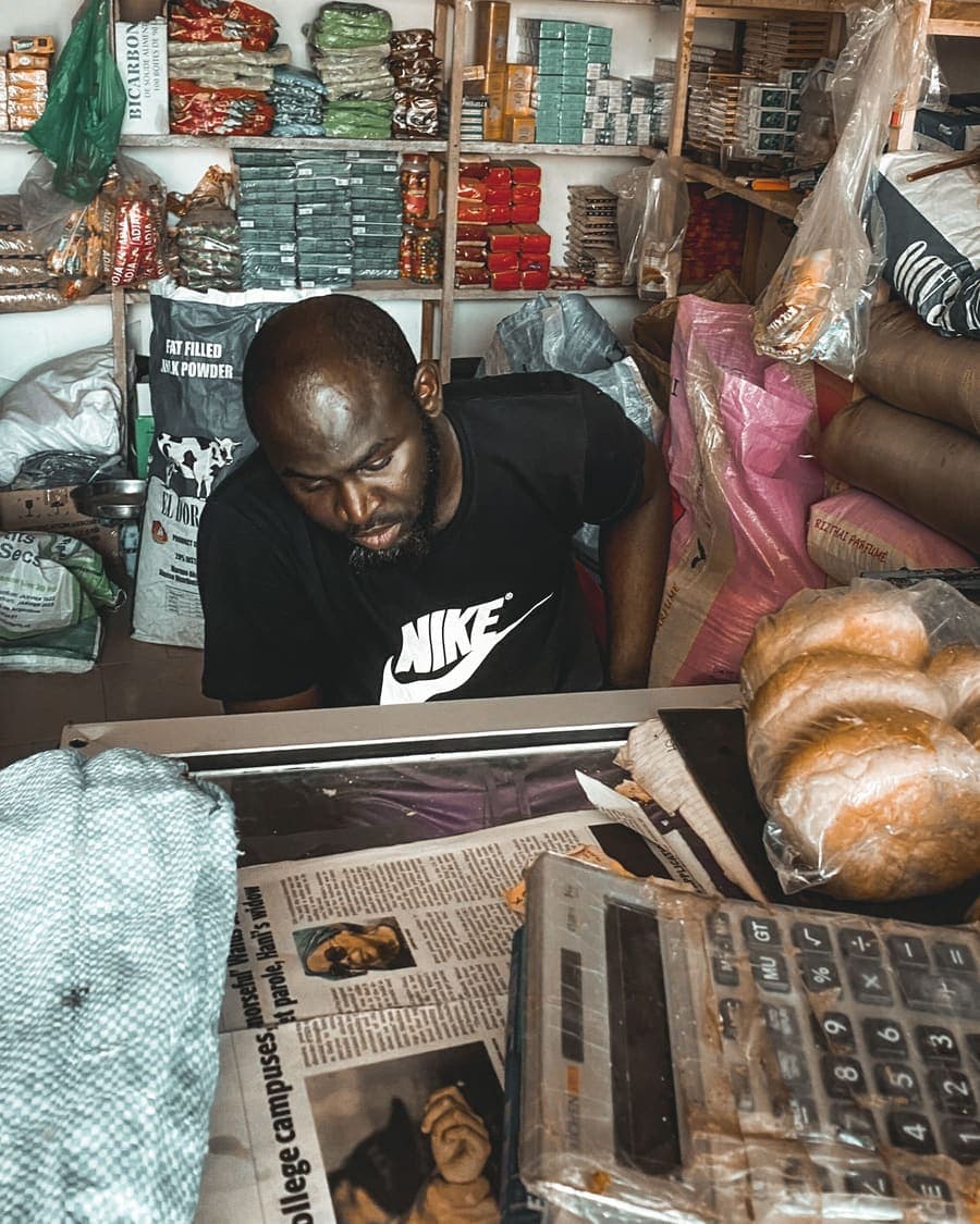 Un boutiquier au comptoir, entre papiers et calculatrice